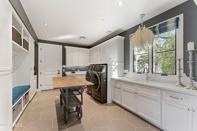 laundry area with separate washer and dryer, sink, cabinets, and light tile patterned flooring