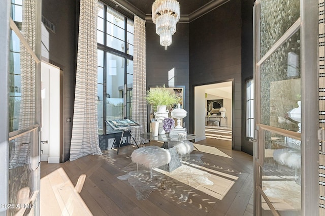 interior space with hardwood / wood-style flooring, a notable chandelier, and a high ceiling