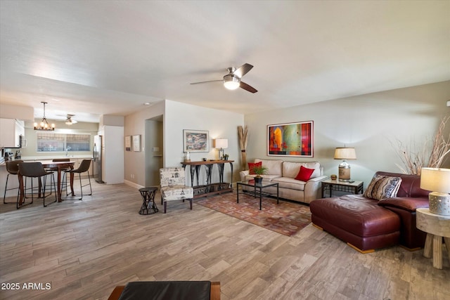 7736 E Hazelwood St, Scottsdale, AZ 85251 - living room featuring ceiling fan with notable chandelier and light wood-style floors