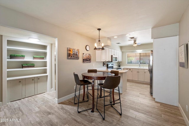 7736 E Hazelwood St, Scottsdale, AZ 85251 - dining room featuring light wood-style floors, baseboards, ceiling fan with notable chandelier, and visible vents