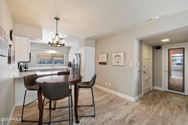 7736 E Hazelwood St, Scottsdale, AZ 85251 - dining area featuring baseboards, a chandelier, and light wood finished floors