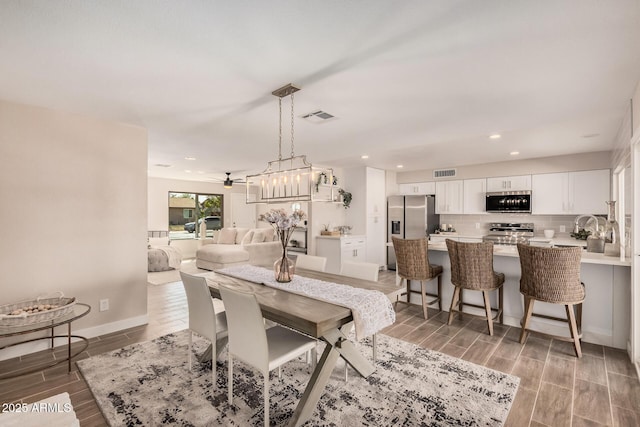 dining area with a ceiling fan, wood tiled floor, visible vents, and recessed lighting