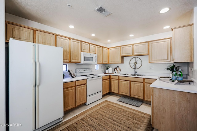 kitchen with sink, light brown cabinetry, light tile patterned flooring, and white appliances