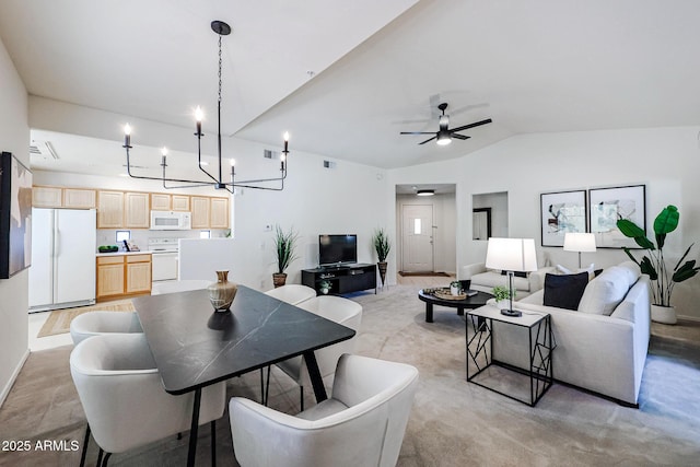 dining space with ceiling fan with notable chandelier, lofted ceiling, and light wood-type flooring