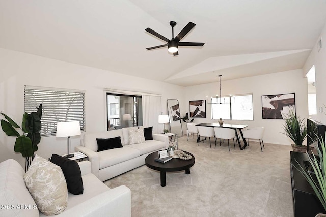 living room featuring ceiling fan with notable chandelier, light carpet, and lofted ceiling