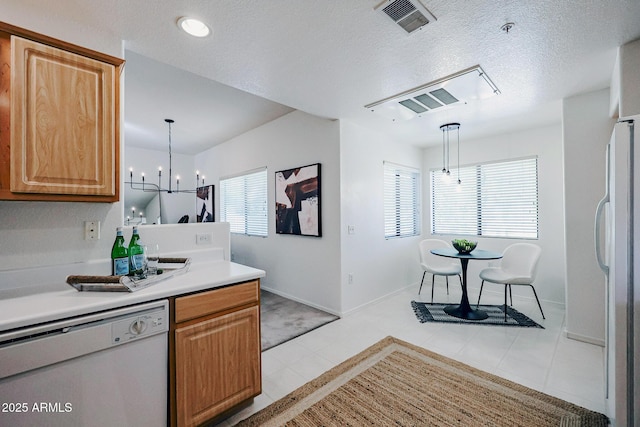 kitchen with light tile patterned floors, hanging light fixtures, white appliances, and a chandelier