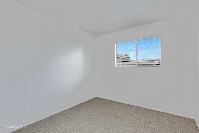 spare room featuring baseboards and carpet