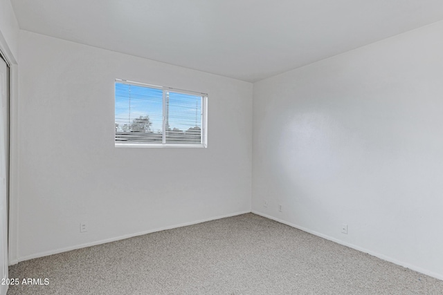 carpeted spare room with baseboards