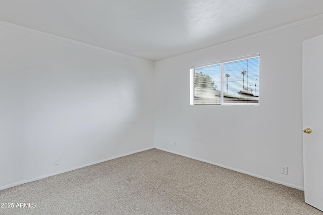 carpeted spare room with baseboards and ornamental molding