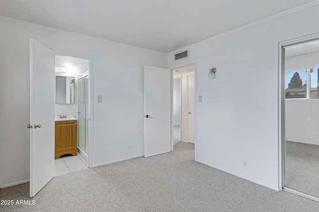 unfurnished bedroom featuring visible vents, crown molding, baseboards, light colored carpet, and a sink