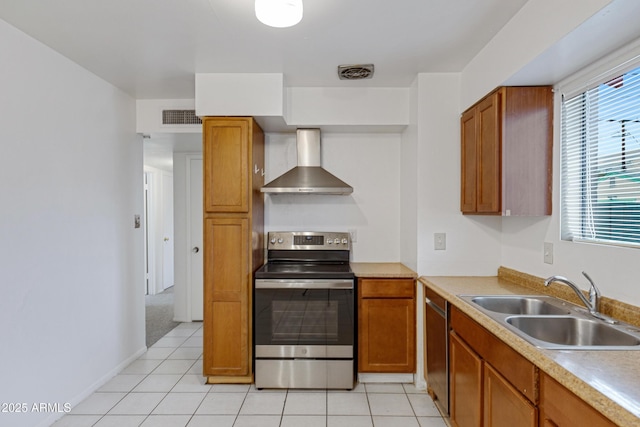 kitchen with wall chimney range hood, visible vents, appliances with stainless steel finishes, and a sink