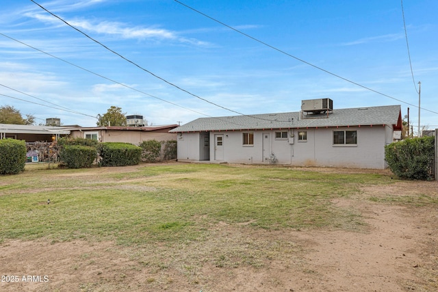 back of house featuring central air condition unit and a lawn