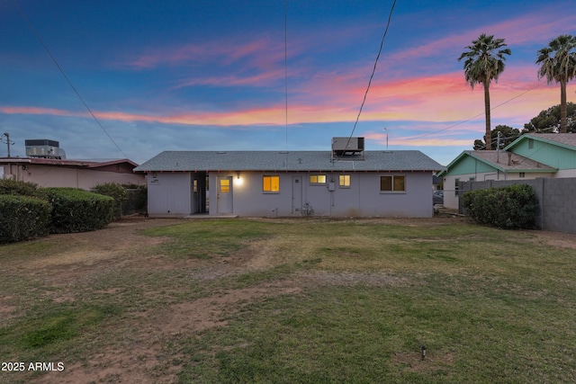 rear view of property with a lawn and fence