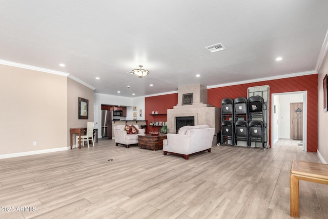 living room with crown molding, light wood-type flooring, recessed lighting, baseboards, and a fireplace