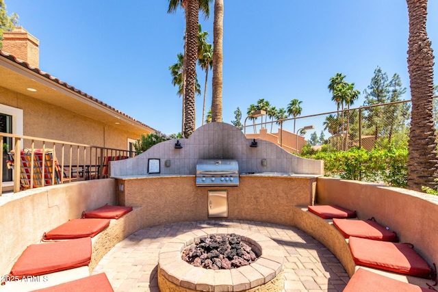 view of patio / terrace featuring area for grilling, a grill, fence, and an outdoor fire pit