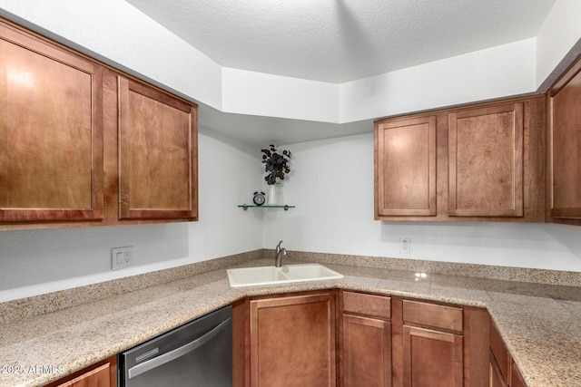 kitchen featuring dishwasher, a sink, brown cabinets, and a textured ceiling