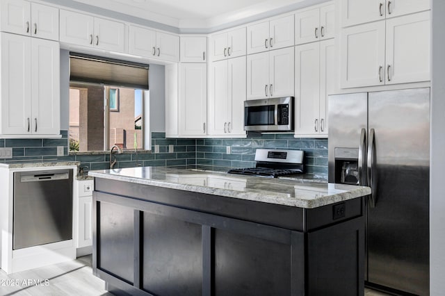 kitchen featuring light stone countertops, stainless steel appliances, and white cabinetry