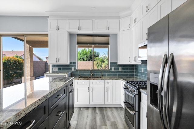 kitchen featuring white cabinets, stainless steel appliances, and a sink