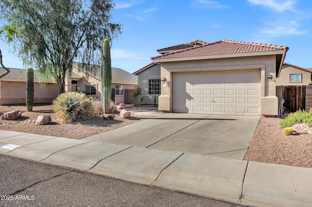 view of front of house with concrete driveway, stucco siding, an attached garage, and a tiled roof
