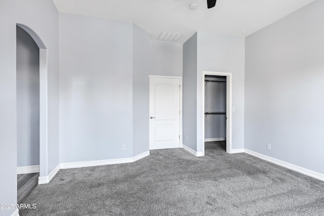 unfurnished bedroom featuring baseboards, carpet, a closet, and visible vents