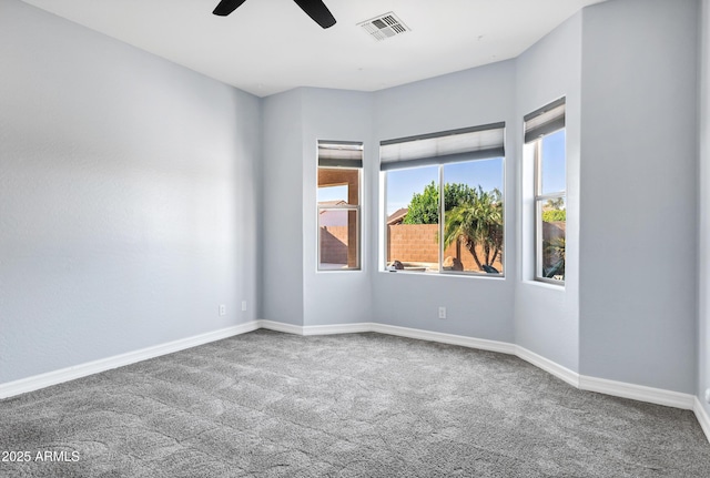 unfurnished room with baseboards, ceiling fan, carpet flooring, and visible vents