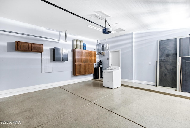 garage featuring baseboards, a garage door opener, and washer / clothes dryer