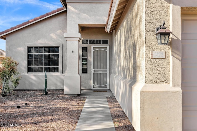 doorway to property featuring stucco siding