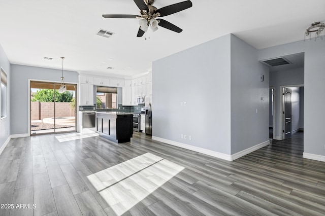 unfurnished living room with baseboards, ceiling fan, wood finished floors, and visible vents