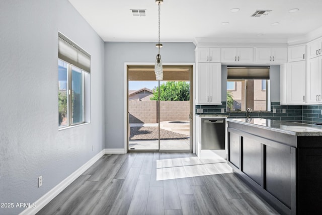 kitchen with dishwasher, light wood-type flooring, white cabinetry, and visible vents