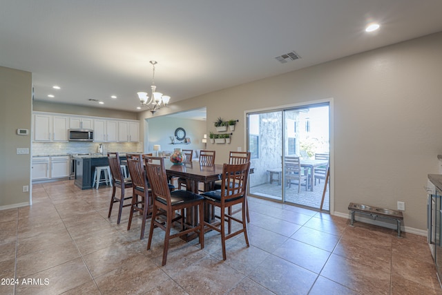 dining space with light tile patterned floors and a chandelier