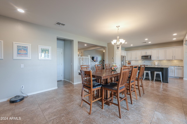 dining area with light tile patterned flooring and an inviting chandelier