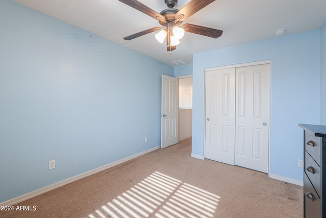 unfurnished bedroom featuring a closet, ceiling fan, and light colored carpet