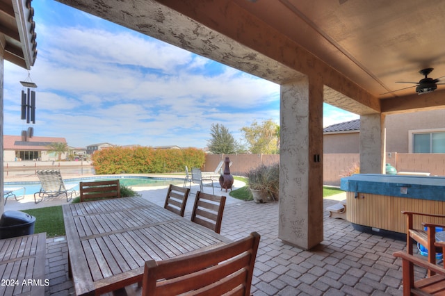 view of patio with ceiling fan and a pool with hot tub