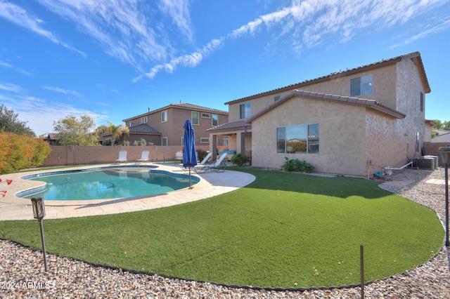 view of swimming pool with central air condition unit, a patio area, and a lawn