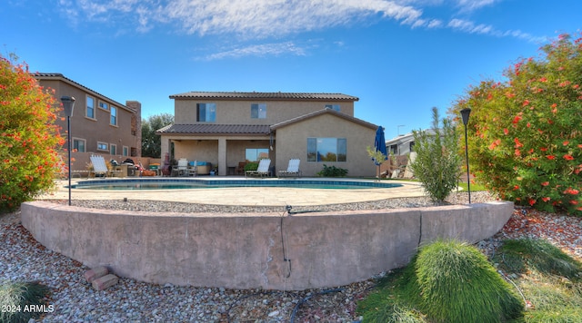 back of house featuring a fenced in pool and a patio area