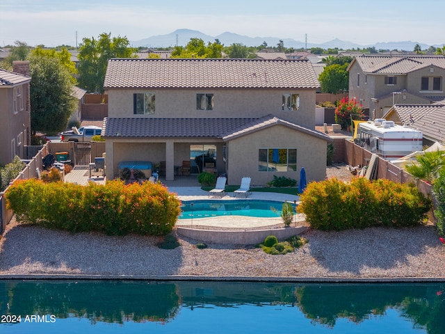 rear view of house with a mountain view and a patio area