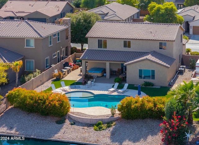 exterior space featuring an in ground hot tub, a patio, and central AC