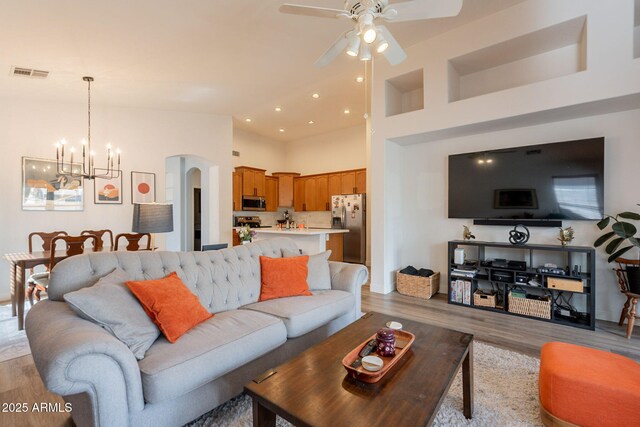 1635 E Harrison St, Chandler, AZ 85225 - living room featuring a chandelier, light wood finished floors, a ceiling fan, arched walkways, and high vaulted ceiling