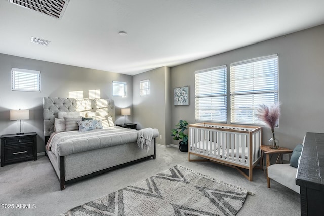 bedroom with multiple windows and light colored carpet