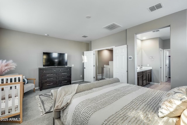 bedroom featuring light carpet and ensuite bath