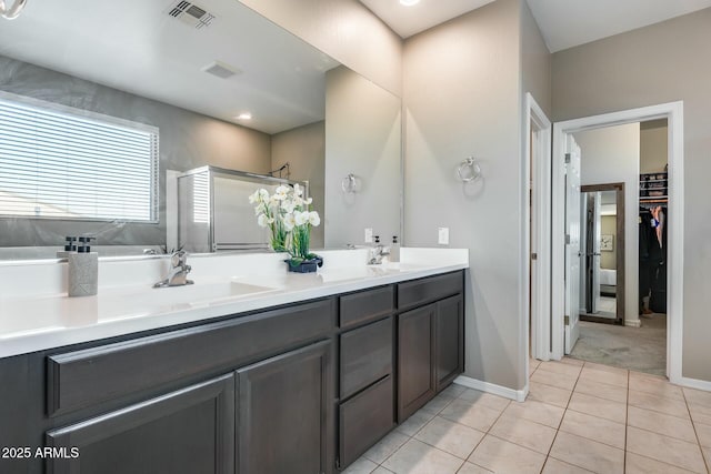 bathroom featuring tile patterned flooring, vanity, and an enclosed shower