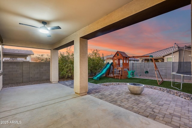 patio terrace at dusk with a trampoline and a playground