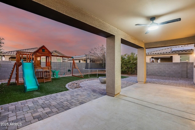 patio terrace at dusk with a trampoline and a playground