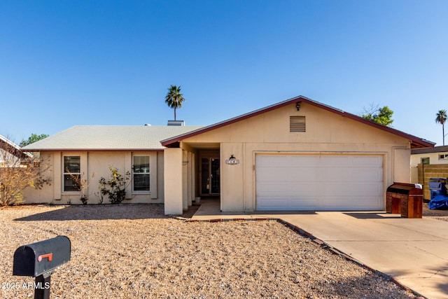 single story home with concrete driveway and an attached garage