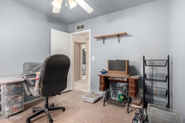 tiled office featuring visible vents, a textured ceiling, and a ceiling fan