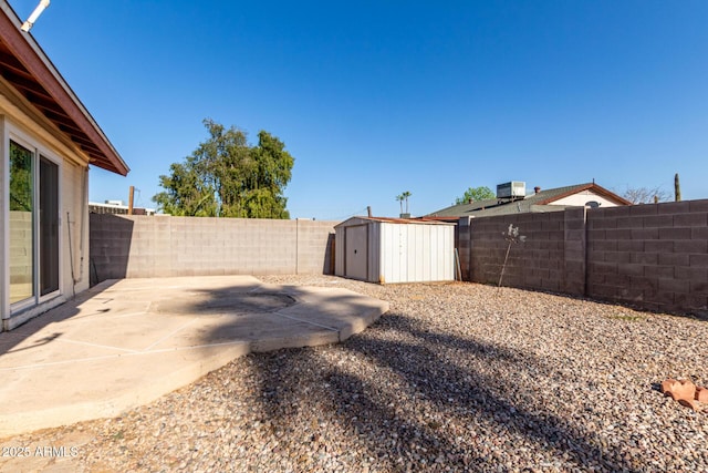 view of yard featuring a patio, an outbuilding, a fenced backyard, a storage shed, and central air condition unit