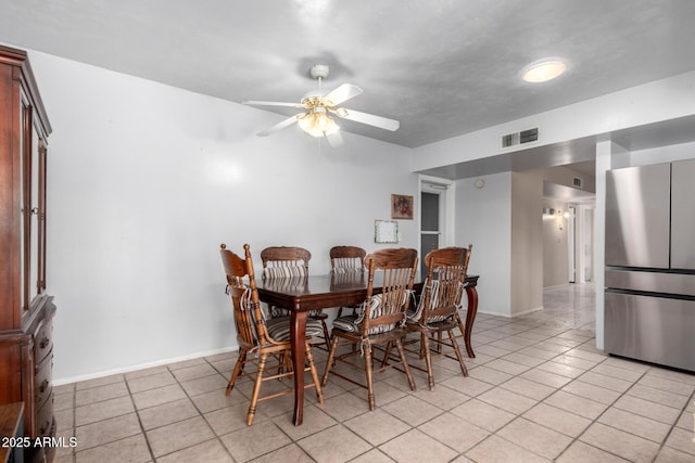 dining area with light tile patterned flooring, visible vents, baseboards, and a ceiling fan