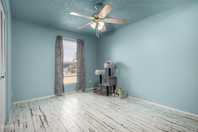 empty room with baseboards, a textured ceiling, and a ceiling fan