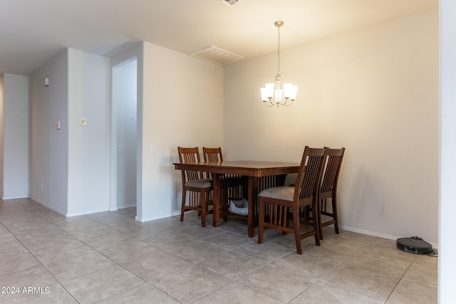 tiled dining room with an inviting chandelier