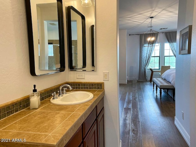 18507 N 94th St, Scottsdale, AZ 85255 - bathroom with baseboards, an inviting chandelier, visible vents, vanity, and hardwood / wood-style floors